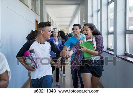 Stock Image - Students running down hallway, laughing. Fotosearch