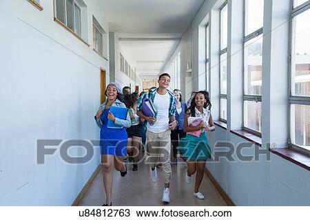 Stock Image - Students running down hallway, laughing. Fotosearch