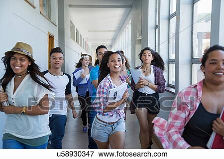 Stock Photo - Students running down hallway, laughing. Fotosearch