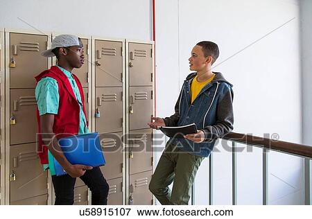 Stock Photo - Students standing beside lockers, chatting. Fotosearch