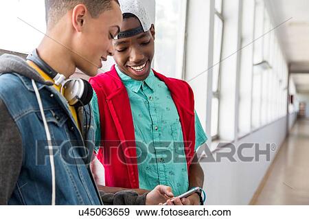 Students standing in hallway, using smartphone View Large Photo Image Stock Photo - Students standing in hallway, using smartphone. Fotosearch