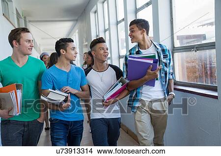 Picture - Students walking down hallway, chatting. Fotosearch