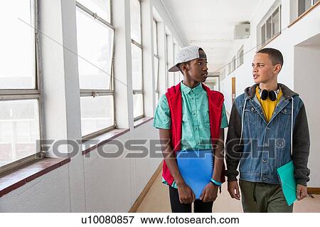 Stock Photo - Students walking down hallway, chatting. Fotosearch