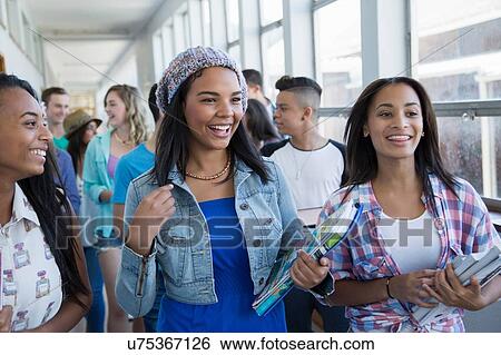 Stock Photograph - Students walking down hallway, chatting. Fotosearch