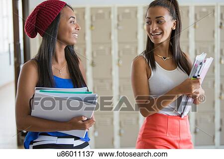 Stock Photo - Students walking past lockers, chatting. Fotosearch