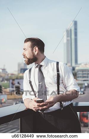 Stylish businessman looking out from office balcony View Large Photo Image Stock Photo - Stylish businessman looking out from office balcony. Fotosearch