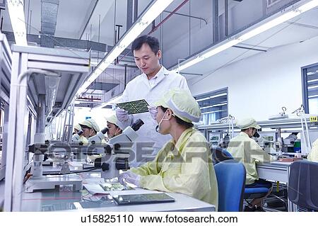 Supervisor overseeing quality check station at factory producing flexible electronic circuit boards. Plant is located in the south of China, in Zhuhai, Guangdong province View Large Photo Image Stock Image - Supervisor overseeing quality check station at factory producing flexible electronic circuit boards. Plant is located in the south of China, in Zhuhai, Guangdong province. Fotosearch