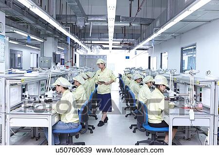Supervisor overseeing quality check station at factory producing flexible electronic circuit boards. Plant is located in the south of China, in Zhuhai, Guangdong province View Large Photo Image Stock Photo - Supervisor overseeing quality check station at factory producing flexible electronic circuit boards. Plant is located in the south of China, in Zhuhai, Guangdong province. Fotosearch