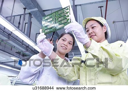 Supervisor overseeing work at quality check station at factory producing flexible electronic circuit boards. Plant is located in the south of China, in Zhuhai, Guangdong province View Large Photo Image Picture - Supervisor overseeing work at quality check station at factory producing flexible electronic circuit boards. Plant is located in the south of China, in Zhuhai, Guangdong province. Fotosearch