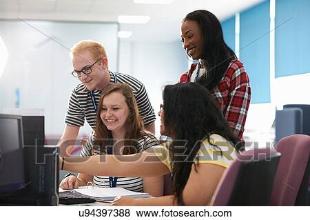Stock Photo - Teacher and students working together in computer class. Fotosearch