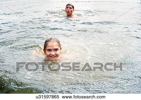 Teenage boy and sister swimming in rural lake View Large Photo Image Stock Photography - Teenage boy and sister swimming in rural lake. Fotosearch