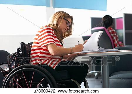 Teenage girl in wheelchair writing up notes in class View Large Photo Image Stock Image - Teenage girl in wheelchair writing up notes in class. Fotosearch