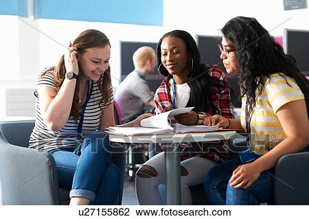 Stock Image - Teenage girls working together in class. Fotosearch