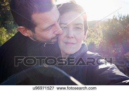 Stock Photo - Tender sunlit portrait of adult couple. Fotosearch