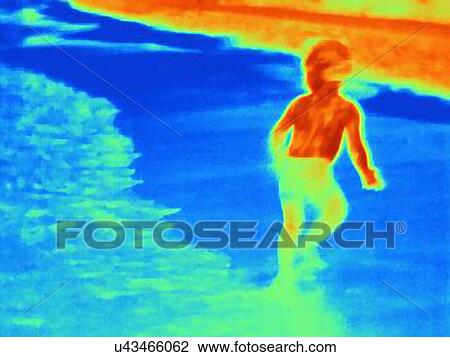 Stock Image - Thermal image of young boy standing in sea. Fotosearch