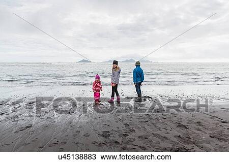 Stock Image - Three girls on beach, Landeyjahofn, Iceland. Fotosearch