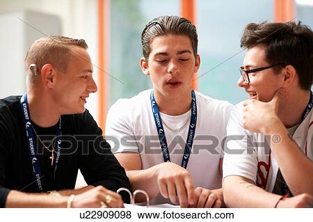Stock Photo - Three male students working together in class. Fotosearch