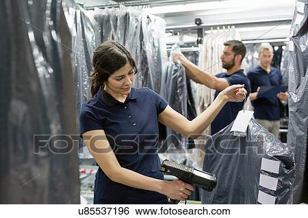 Three warehouse workers doing garment stock take in distribution warehouse View Large Photo Image Stock Photograph - Three warehouse workers doing garment stock take in distribution warehouse. Fotosearch