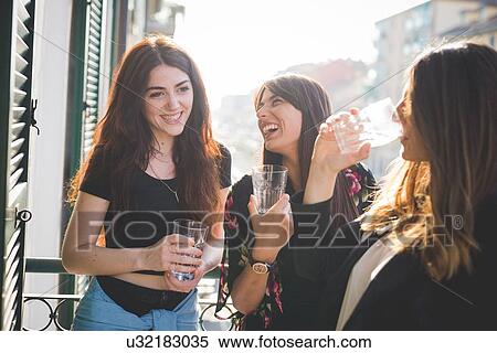 Three young female friends laughing and chatting on waterfront balcony View Large Photo Image Stock Photography - Three young female friends laughing and chatting on waterfront balcony. Fotosearch