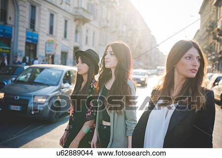 Picture - Three young women strolling in city. Fotosearch