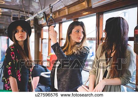 Three young women travelling on city tram View Large Photo Image Stock Photograph - Three young women travelling on city tram. Fotosearch