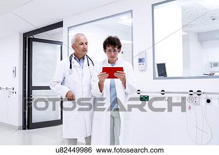 Stock Photograph - Two doctors looking at digital tablet. Fotosearch