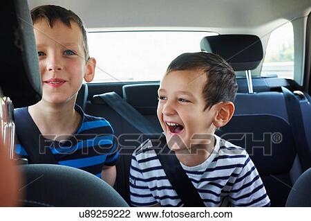 Two happy young brothers traveling in car back seat View Large Photo Image Stock Image - Two happy young brothers traveling in car back seat. Fotosearch