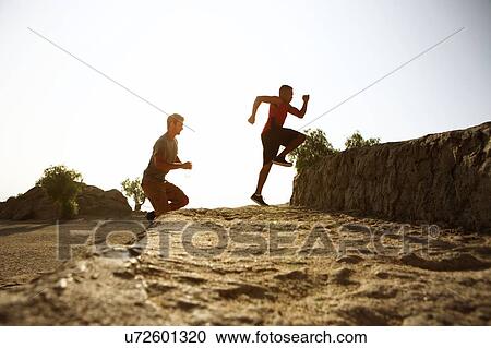 Two male friends running together, outdoors View Large Photo Image Stock Image - Two male friends running together, outdoors. Fotosearch