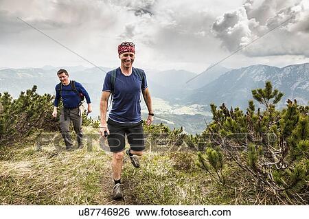Two mature male hikers hiking in mountains, Achenkirch, Austria View Large Photo Image Stock Photograph - Two mature male hikers hiking in mountains, Achenkirch, Austria. Fotosearch