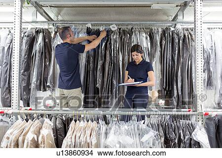 Two warehouse workers preparing garments in distribution warehouse View Large Photo Image Picture - Two warehouse workers preparing garments in distribution warehouse. Fotosearch