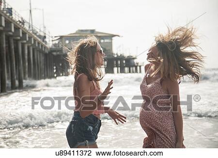 Two young women talking on windswept beach, Santa Monica, California, USA View Large Photo Image Stock Image - Two young women talking on windswept beach, Santa Monica, California, USA. Fotosearch