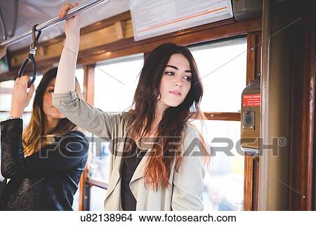 Two young women travelling on city tram View Large Photo Image Picture - Two young women travelling on city tram. Fotosearch