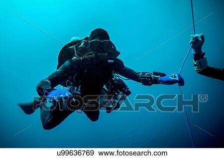 Underwater view of technical diver using a rebreather device to locate shipwreck, Lombok, Indonesia View Large Photo Image Stock Photo - Underwater view of technical diver using a rebreather device to locate shipwreck, Lombok, Indonesia. Fotosearch