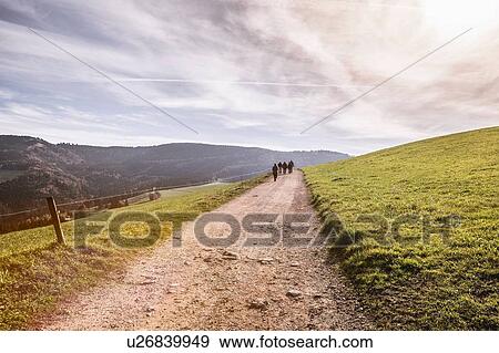 View of landscape with distant people walking along dirt track View Large Photo Image Stock Photo - View of landscape with distant people walking along dirt track. Fotosearch