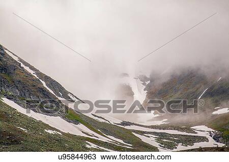 Stock Image - View of low cloud and snowy valley, Ural mountains, Russia. Fotosearch