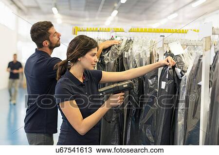 Stock Image - Warehouse worker preparing garment order in distribution warehouse. Fotosearch