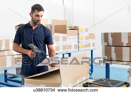 Warehouse worker scanning paperwork in distribution warehouse View Large Photo Image Picture - Warehouse worker scanning paperwork in distribution warehouse. Fotosearch
