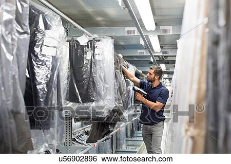 Stock Photograph - Warehouse worker stock taking in distribution warehouse. Fotosearch