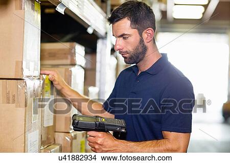 Picture - Warehouse worker using barcode scanner in distribution warehouse. Fotosearch