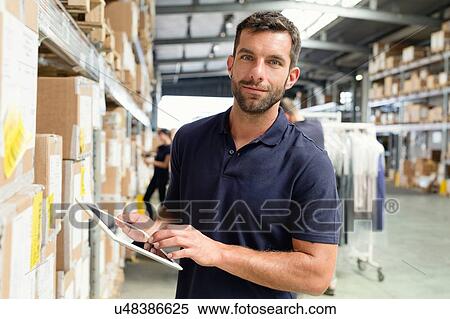 Warehouse worker using digital tablet in distribution warehouse View Large Photo Image Stock Photography - Warehouse worker using digital tablet in distribution warehouse. Fotosearch