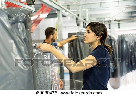 Stock Photograph - Warehouse workers preparing garment orders in distribution warehouse. Fotosearch