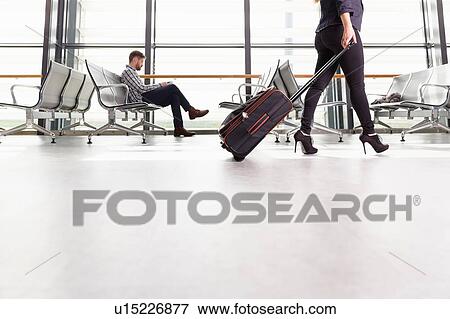 Woman on the move through departure lounge with suitcase View Large Photo Image Stock Photo - Woman on the move through departure lounge with suitcase. Fotosearch