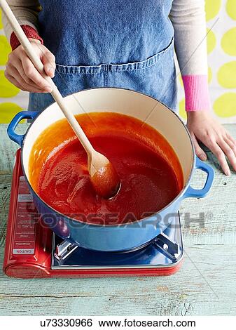 Woman preparing tomato ketchup recipe step 3, stirring pureed tomatoes View Large Photo Image Stock Photograph - Woman preparing tomato ketchup recipe step 3, stirring pureed tomatoes. Fotosearch