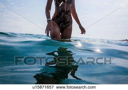 Stock Photo - Woman standing in sea. Fotosearch