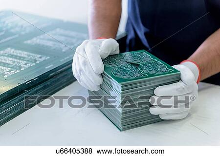Stock Photo - Worker arranging cut circuit boards in circuit board factory. Fotosearch