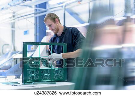 Worker cutting circuit boards in circuit board factory View Large Photo Image Stock Photograph - Worker cutting circuit boards in circuit board factory. Fotosearch