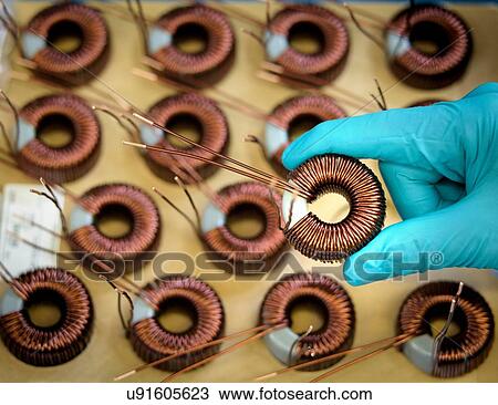 Stock Image - Worker holding Electromagnetic coils in electromagnetics factory, close-up. Fotosearch