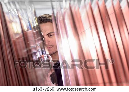 Stock Image - Worker inspecting circuit board base layers in circuit board factory. Fotosearch