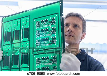 Worker inspecting circuit board during manufacture in circuit board factory View Large Photo Image Stock Image - Worker inspecting circuit board during manufacture in circuit board factory. Fotosearch