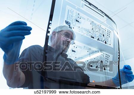 Worker inspecting circuit board negative sheet in circuit board factory View Large Photo Image Stock Photo - Worker inspecting circuit board negative sheet in circuit board factory. Fotosearch
